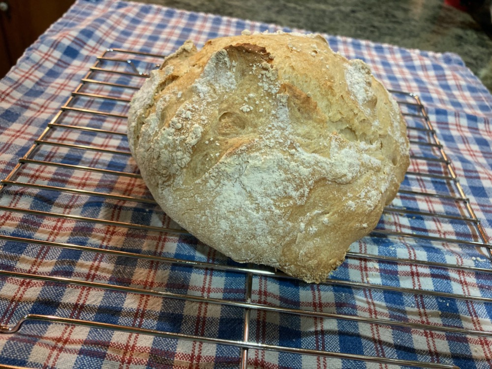 fresh baked loaf of bread cooling on a wire rack